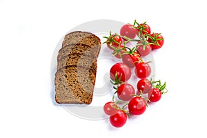 Composition of black bread and bunch of cherry tomatoes