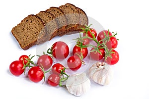 Composition of black bread slices, bunch of tomatoes and garlic