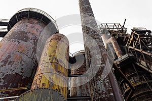 Composition of blast furnaces and smokestacks in an old steel mill, rust and peeling paint patinas