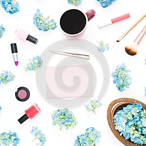 Composition of blue hydrangea flowers with feminine cosmetics, diary and mug of coffee on white background. Flat lay, top view. Fl