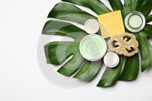 Composition with body care products, wisp and green leaf on white background, top view photo