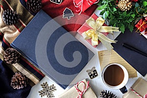 Composition of book with cup of coffee and Christmas decorations on table