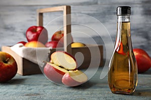 Composition with bottle of apple vinegar on table