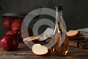 Composition with bottle of apple vinegar on table