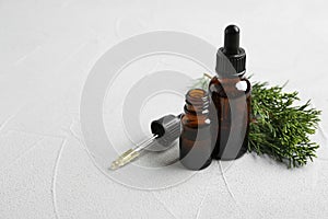 Composition with bottles of conifer essential oil on light background