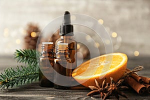Composition with bottles of essential oils and sliced orange on table. Natural cosmetics