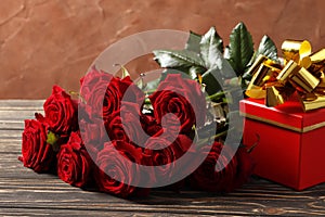 Composition from a bouquet of beautiful red roses, gift box on a wooden background. Valentine`s day