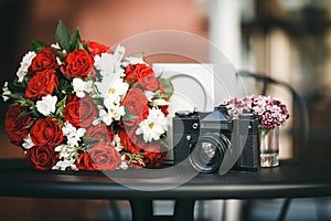 Composition of bouquet with red roses and chamomile and film cam