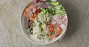 Composition of bowl of rice, salmon and vegetables on white background