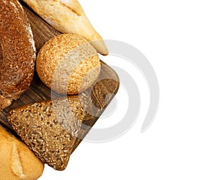 Composition with bread and rolls on cutting board isolated on white