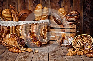 Composition with bread and rolls in wicker basket.