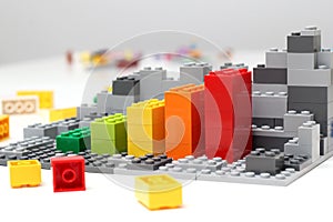 Progress chart made of bricks. Isometric composition of colourful toys on white table.