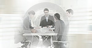 Composition of business people in meeting room over cityscape with motion blur