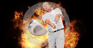 Composition of caucasian male golf player holding golf club over flames on black background