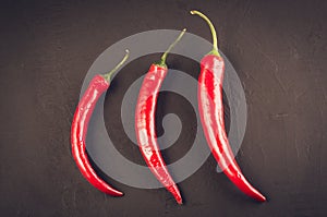 composition of chili peppe on a dark stone/red hot Chile pepper on a dark stone background. Top view