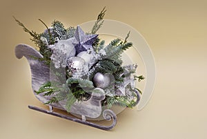 Composition of the Christmas decorations Sleigh with Fir Branche and Silver Baubbles or Globes