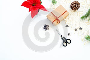 Composition of Christmas decorations on white background with gift box with red ribbon, pine branches, pine cone, decorative stars