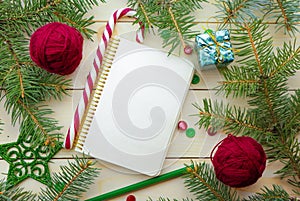Composition with Christmas tree, notebook and yarn balls as decorations on wooden background