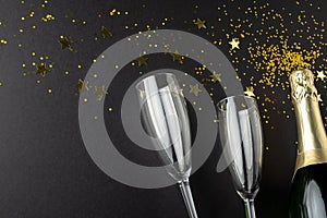 Composition of close up of new years champagne and confetti on black background