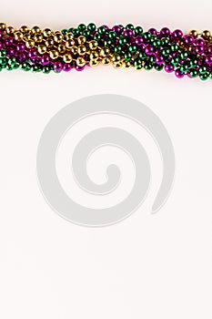 Composition of colourful mardi gras beads with copy space on white background with copy space