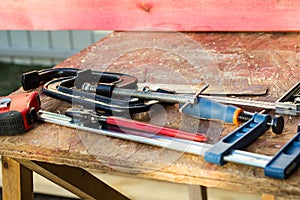 Composition of construction tools on an old wooden table of pliers, pipe wrench, screwdriver, clamps, roulette