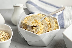 Composition with cooked quinoa in white ceramic bowl