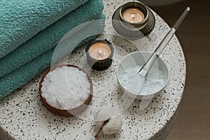 Composition with cosmetic alginate facial mask for spa treatments, aroma oil, epsom or magnium salt, candles and terry towels on a