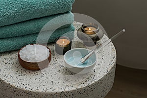 Composition with cosmetic alginate facial mask for spa treatments, aroma oil, epsom or magnium salt, candles and terry towels on a