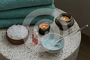 Composition with cosmetic alginate facial mask for spa treatments, aroma oil, epsom or magnium salt, candles and terry towels on a