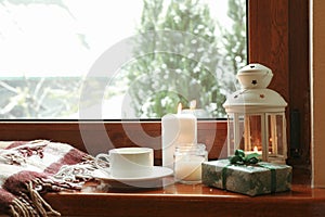 Composition of cozy winter day on wooden windowsill