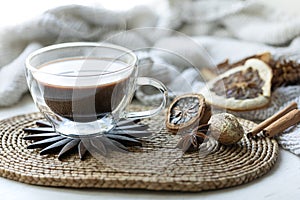 Composition with a cup of coffee on a blurred background with a knitted element.