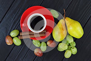 Composition with cup of coffee, grapes and ripe pears, view from above