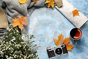 Composition with cup of delicious mulled wine, photo camera and autumn leaves on color background