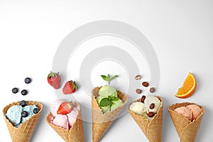 Composition with delicious ice creams in waffle cones on white background