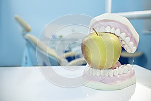 Composition. Dentures biting an apple in dental surgery