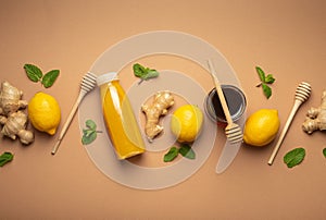 Composition with detox drink, lemons, mint, ginger, honey in glass jar and honey wooden dippers top view. Food for