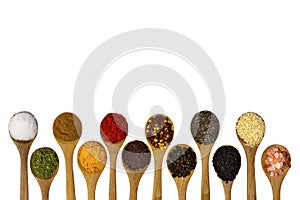 Composition with different aromatic spices in wooden spoons on white background