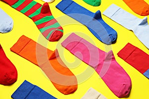 Composition of different colorful socks on yellow background