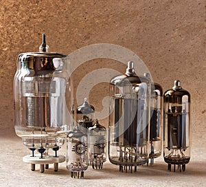 Composition of different electronic vacuum tubes on kraft paper background.