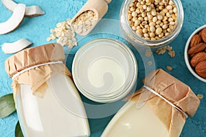 Composition with different types milk, coconut, soybeat seets, almound, oatmaet on blue background, closeup