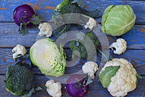 Composition from different varieties of cabbage on wooden background. Cauliflower, kohlrabi, broccoli, white head cabbage. Organic