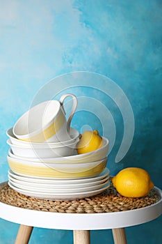 Composition with dinnerware on table against color background, space for text
