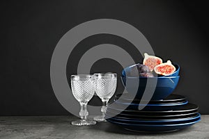 Composition with dinnerware on table against dark background, space for text.