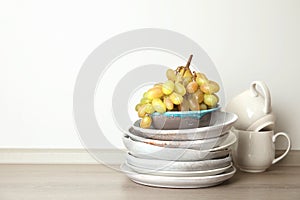 Composition with dinnerware on table against light background, space for text