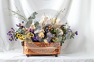 composition of dry flowers in a vase, white fabric background, still life