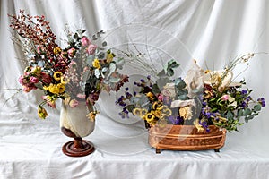 composition of dry flowers in a vase, white fabric background, still life