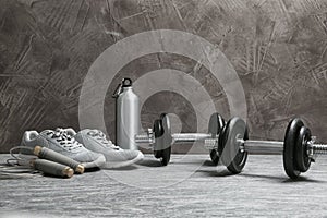 Composition with dumbbells and fitness accessories on floor.