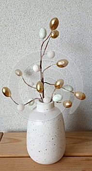 Composition Easter eggs on a branch in vase white background