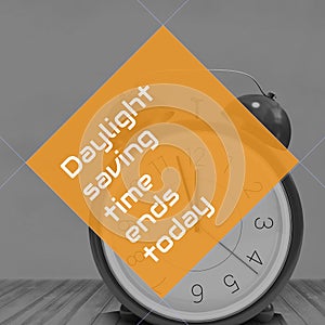 Composition of end of daylight saving time text over clock