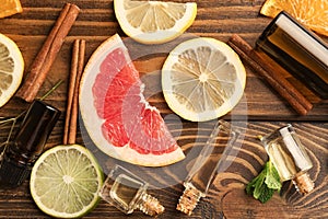 Composition with essential oils and citrus fruits on wooden background